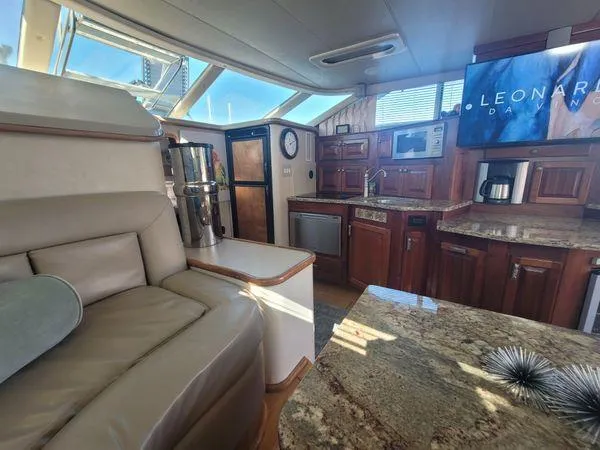 Slide: The Image of Interior of 1995 Sea Ray 440 Express Bridge with luxurious seating and modern kitchen amenities. - 13