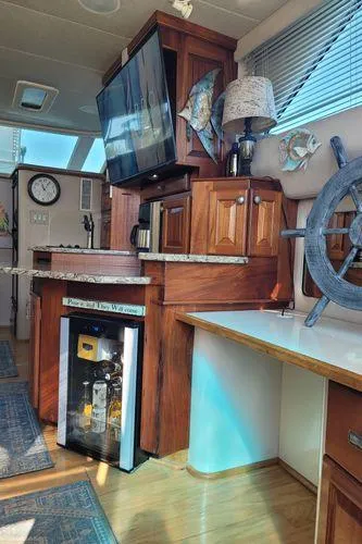 Slide: The Image of Interior of 1995 Sea Ray 440 Express Bridge with wooden cabinetry and nautical decor. - 16