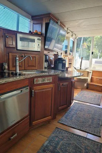 Slide: The Image of Interior of 1995 Sea Ray 440 Express Bridge with modern kitchen and wooden cabinetry. - 17