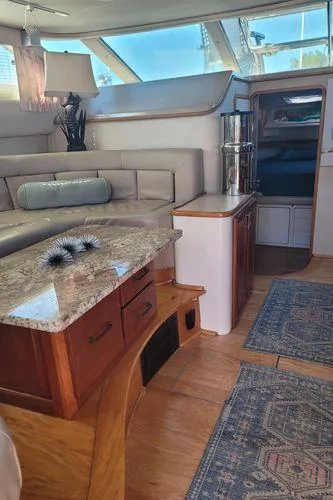 Slide: The Image of Interior of 1995 Sea Ray 440 Express Bridge with elegant seating and wooden cabinetry. - 18