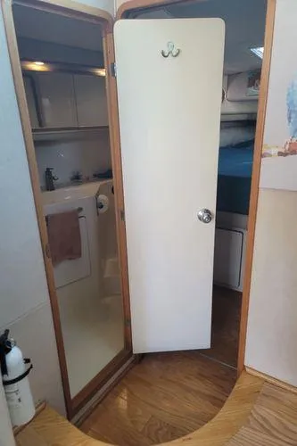 Slide: The Image of Interior view of 1995 Sea Ray 440 Express Bridge, featuring a bathroom and wooden flooring. - 22