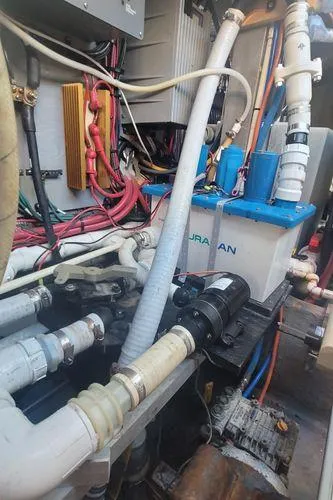 Slide: The Image of Engine room of 1995 Sea Ray 440 Express Bridge with visible pipes and wiring. - 29
