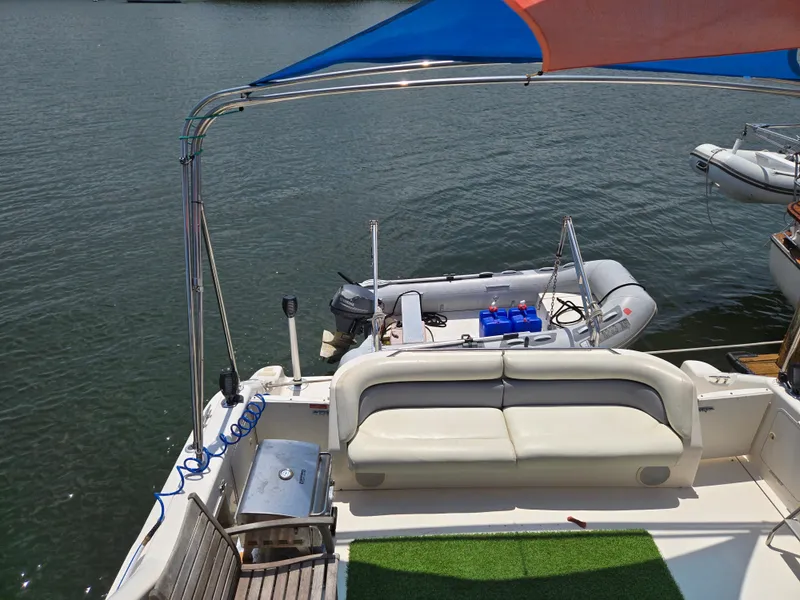 Slide: The Image of 1995 Sea Ray 440 Express Bridge with seating area and small boat on water. - 3