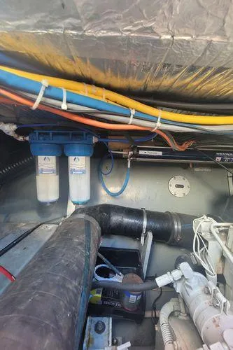 Slide: The Image of Engine room of 1995 Sea Ray 440 Express Bridge with visible wiring and filtration system. - 30