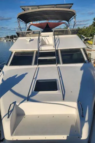 Slide: The Image of 1995 Sea Ray 440 Express Bridge yacht with spacious deck and flybridge, docked in marina. - 4