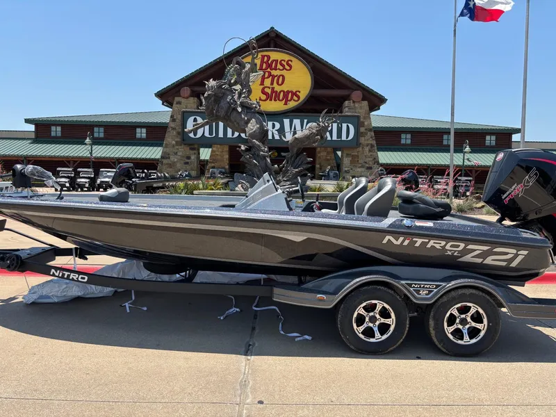 The Image of 2025 Nitro Z21 XL boat on trailer, parked outdoors under clear blue sky. - 0