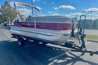 The Image of 2025 Sun Tracker Party Barge 18 DLX pontoon boat on trailer, parked outdoors. - 0