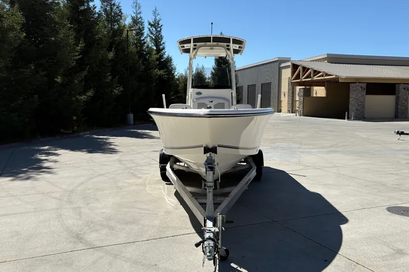 Slide: The Image of 2025 Mako 214 Center Console boat on trailer in sunny outdoor setting. - 6