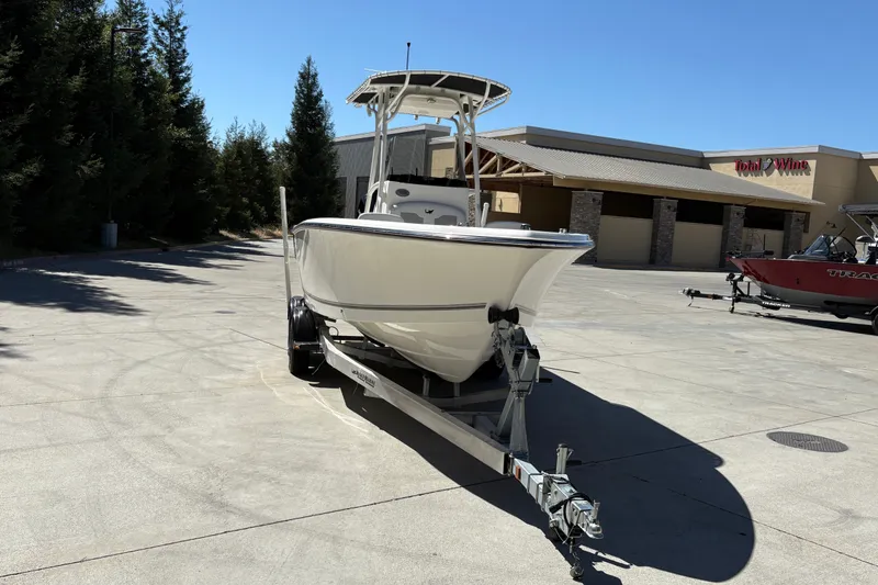 Slide: The Image of 2025 Mako 214 Center Console boat on trailer in sunny parking lot. - 7
