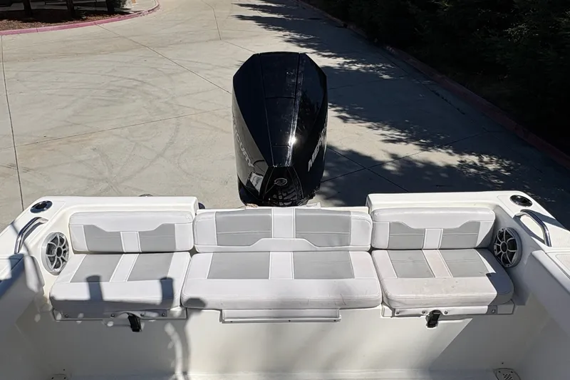Slide: The Image of 2025 Mako 214 Center Console boat with cushioned seating and powerful outboard motor. - 17