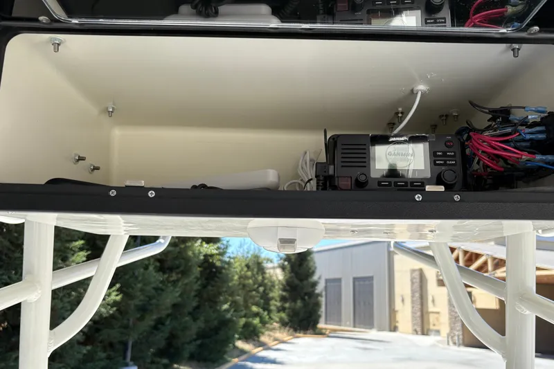 Slide: The Image of 2025 Mako 214 Center Console electronics compartment with Garmin device and wiring. - 27