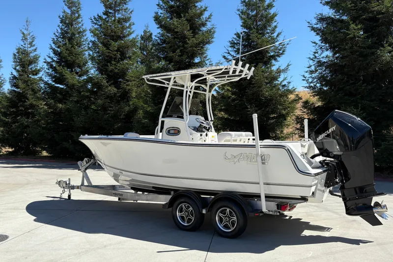 Slide: The Image of 2025 Mako 214 Center Console boat on trailer, surrounded by trees. - 4