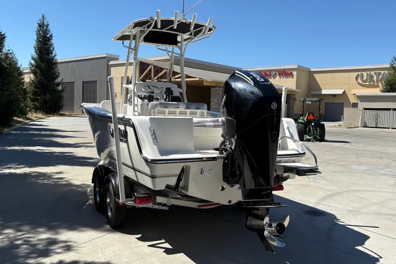 Slide: The Image of 2025 Mako 214 Center Console boat on trailer, parked outdoors in sunny setting. - 10