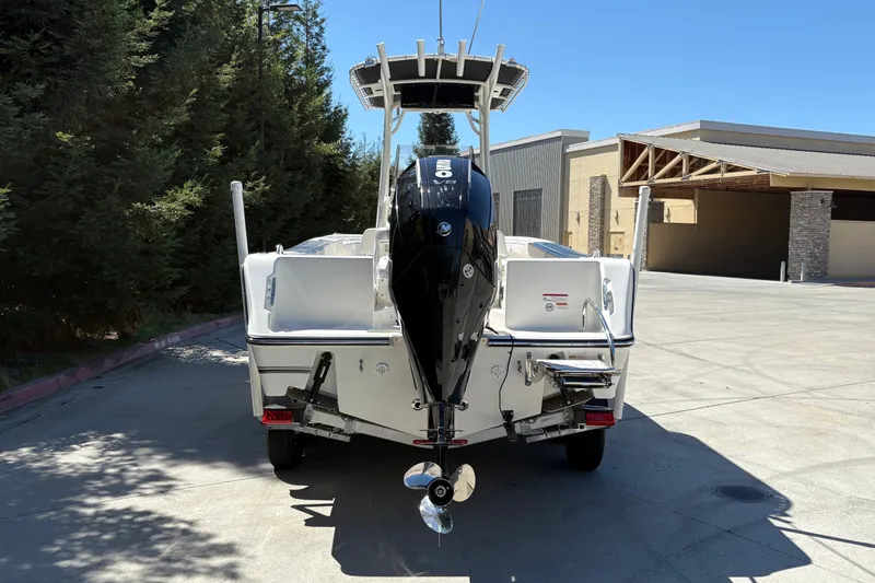 Slide: The Image of 2025 Mako 214 Center Console boat with powerful outboard motor, parked outdoors. - 11