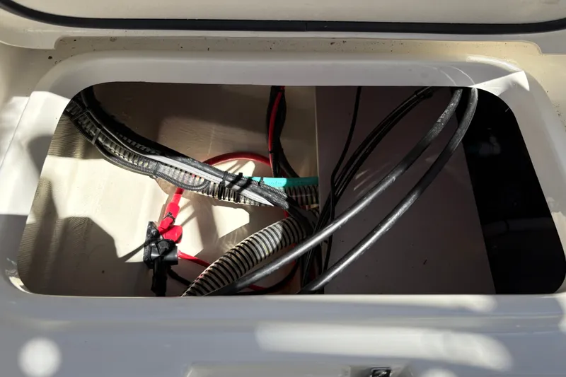 Slide: The Image of Open compartment of 2025 Mako 214 Center Console boat showing wiring and cables. - 21
