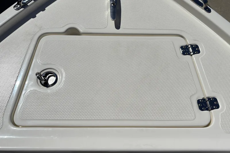Slide: The Image of Hatch cover on 2025 Mako 214 Center Console boat, featuring textured surface and metal hinges. - 33