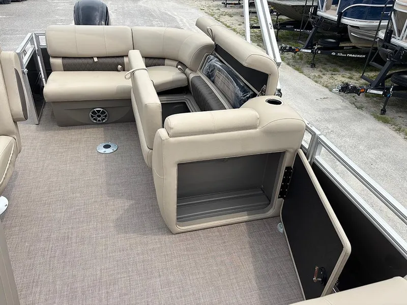 Slide: The Image of 2025 Sun Tracker Party Barge 20 DLX interior with beige seating and storage compartments. - 19