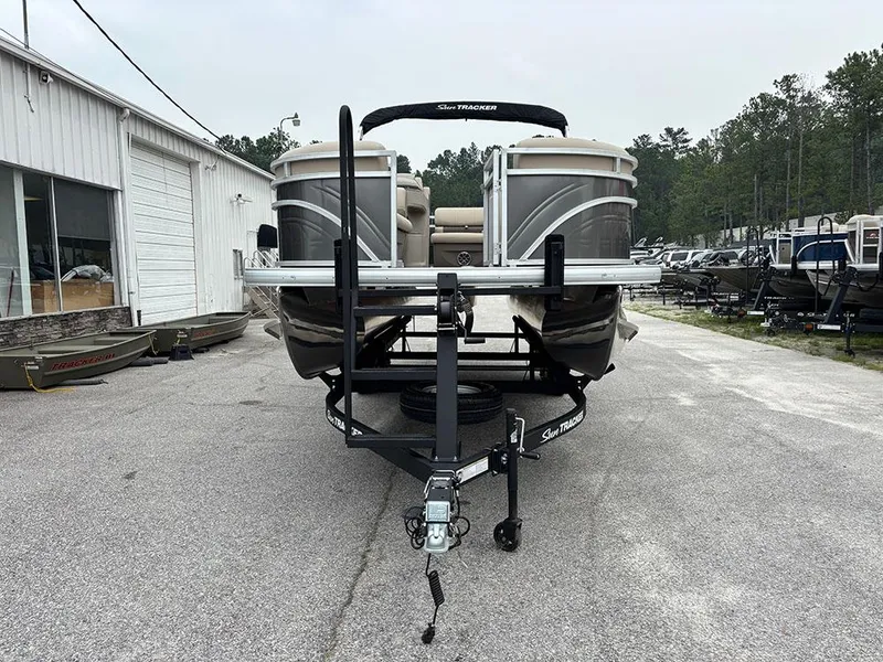 Slide: The Image of 2025 Sun Tracker Party Barge 20 DLX pontoon boat on trailer in outdoor lot. - 3