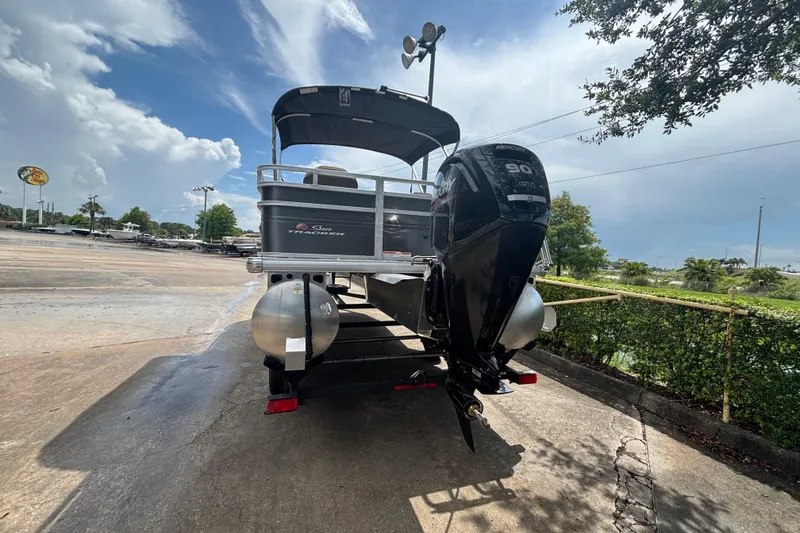 Slide: The Image of 2025 Sun Tracker Fishin' Barge 20 DLX pontoon boat with Mercury engine, parked outdoors. - 56