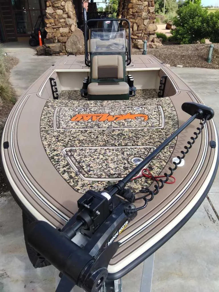 Slide: The Image of 2025 Mako 18 Pro Skiff Backwater Edition boat with camo deck and trolling motor. - 2