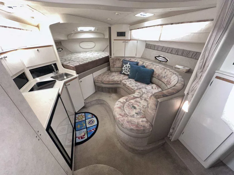 Slide: The Image of Interior of 2000 Bayliner 3055 Ciera Sunbridge with cozy seating and compact kitchen area. - 14