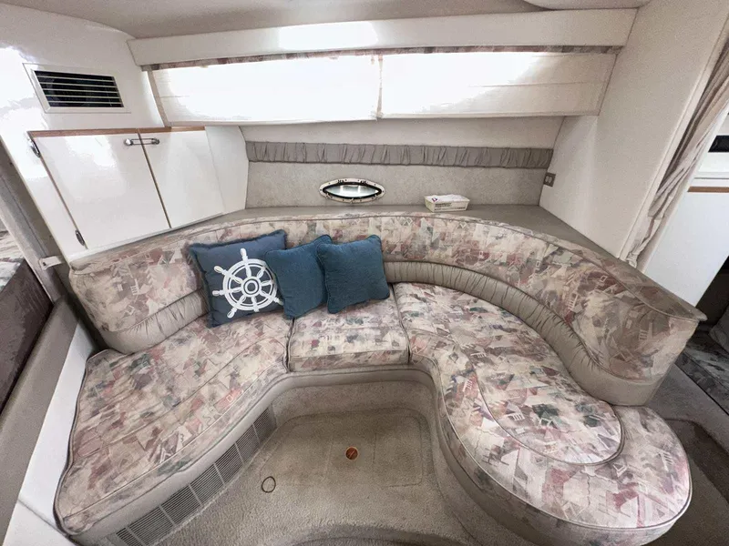 Slide: The Image of Interior of 2000 Bayliner 3055 Ciera Sunbridge with floral-patterned seating and decorative pillows. - 15
