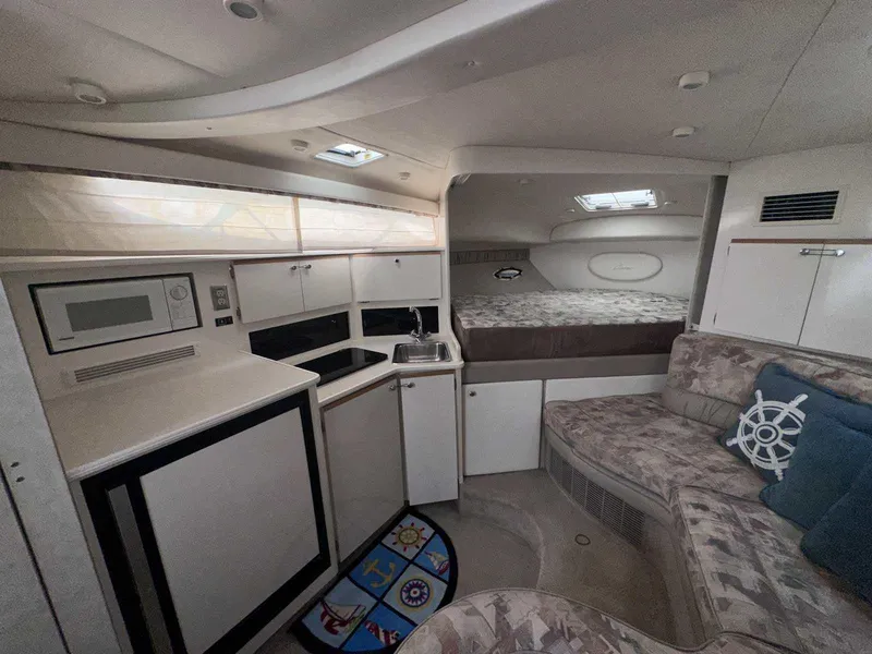 Slide: The Image of Interior of 2000 Bayliner 3055 Ciera Sunbridge with kitchenette and cozy seating area. - 17