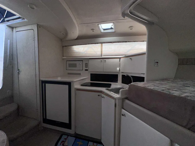 Slide: The Image of Interior of 2000 Bayliner 3055 Ciera Sunbridge DX/LX, featuring kitchenette and sleeping area. - 18