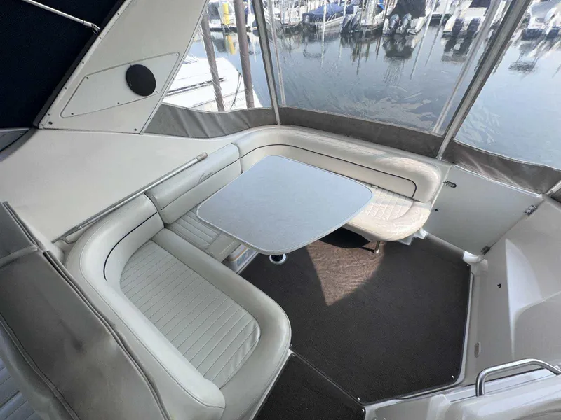 Slide: The Image of 2000 Bayliner 3055 Ciera Sunbridge DX/LX interior with seating and table, docked at marina. - 5