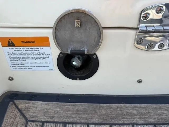 Slide: The Image of 2014 Chris-Craft Launch 25 boat fuel cap with warning label and metal hinge detail. - 11