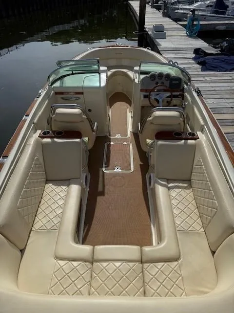 Slide: The Image of 2014 Chris-Craft Launch 25 boat with luxurious beige seating and elegant dashboard, docked at marina. - 13