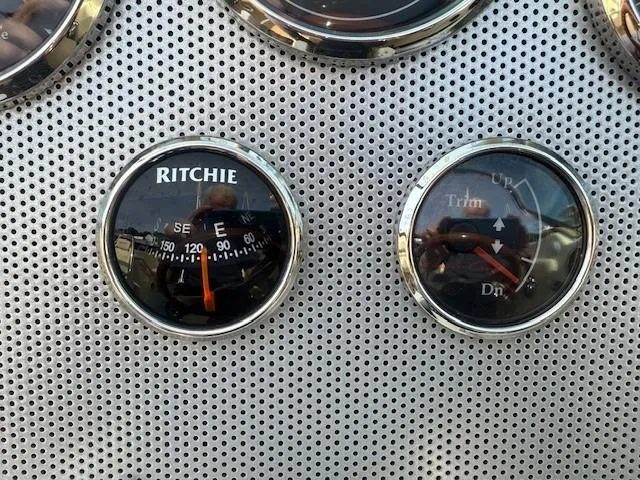 Slide: The Image of Compass and trim gauges on 2014 Chris-Craft Launch 25 boat dashboard. - 16