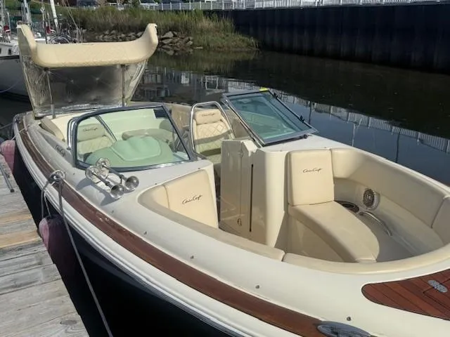 Slide: The Image of 2014 Chris-Craft Launch 25 boat docked, featuring elegant seating and classic design. - 26