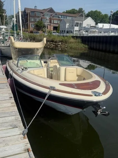 Slide: The Image of 2014 Chris-Craft Launch 25 boat docked in a marina, featuring elegant design and classic styling. - 28
