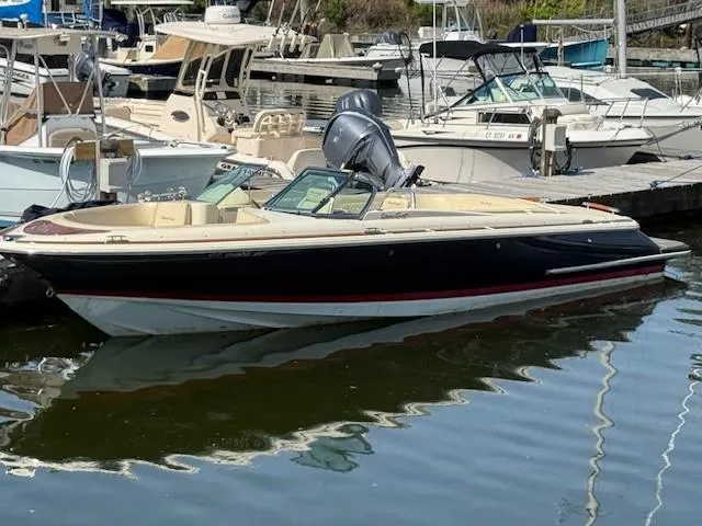 Slide: The Image of 2014 Chris-Craft Launch 25 boat docked in a marina, featuring sleek design and classic styling. - 3