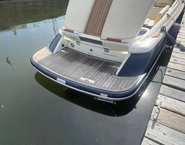Slide: The Image of 2014 Chris-Craft Launch 25 boat docked, showcasing elegant rear deck design. - 31