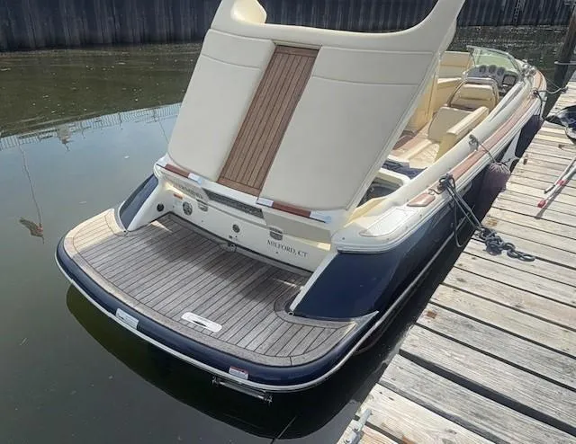 Slide: The Image of 2014 Chris-Craft Launch 25 boat docked, showcasing elegant design and spacious seating. - 32