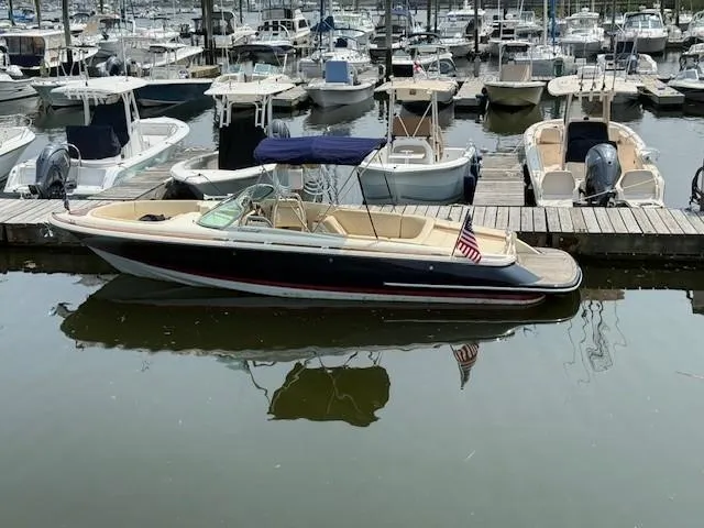 Slide: The Image of 2014 Chris-Craft Launch 25 boat docked in a marina with other vessels. - 6