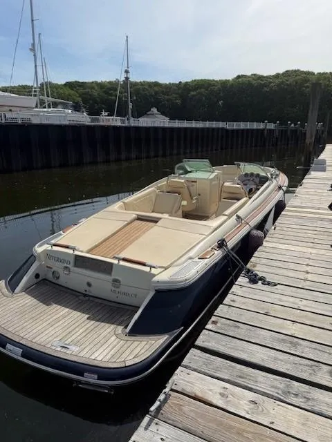 Slide: The Image of 2014 Chris-Craft Launch 25 boat docked at a marina, featuring elegant design and spacious seating. - 8