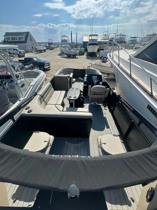 Slide: The Image of 2023 Viaggio Lago R boat with spacious seating, docked at a marina under a sunny sky. - 13