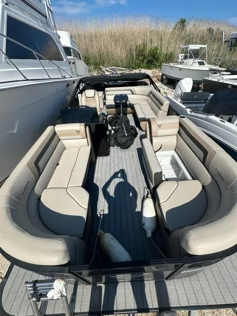 Slide: The Image of 2023 Viaggio Lago R boat with spacious seating, docked outdoors under clear skies. - 16