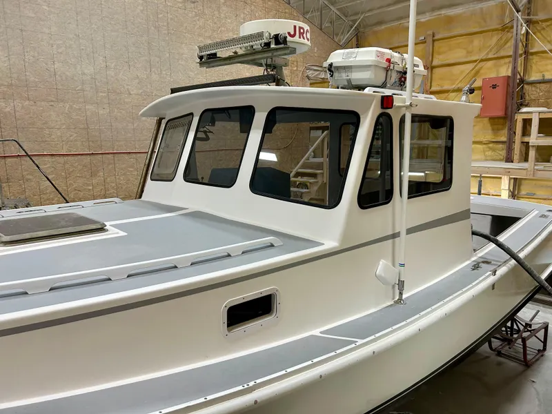 Slide: The Image of 1980 Holland 32 boat with white cabin and advanced navigation equipment in a workshop. - 11