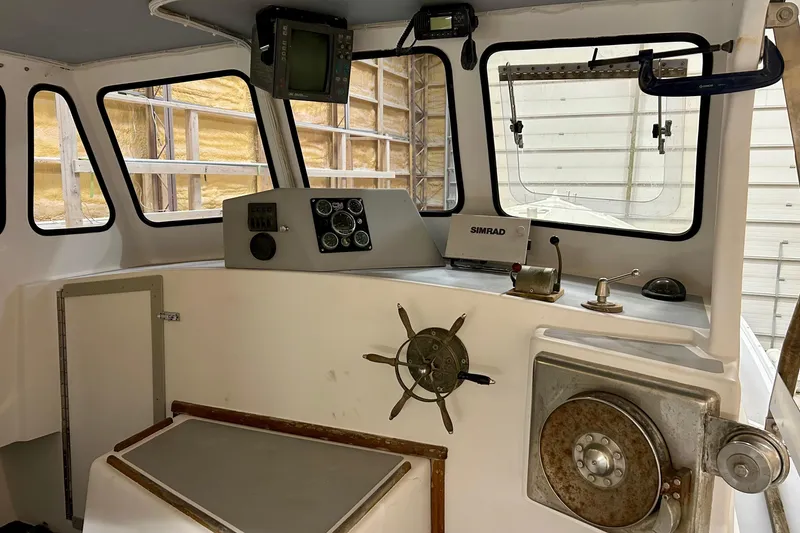Slide: The Image of Interior of a 1980 Holland 32 boat, featuring navigation equipment and steering wheel. - 9
