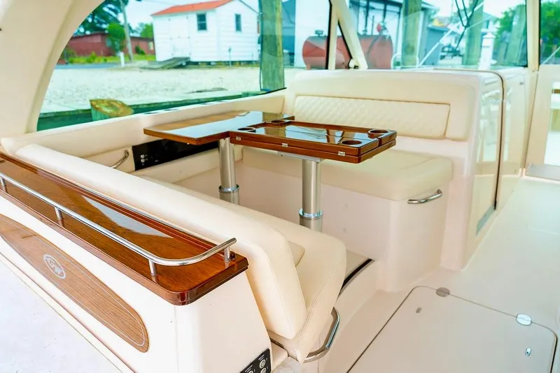 Slide: The Image of 2024 Grady-White Freedom 415 boat interior with elegant seating and wooden table. - 11