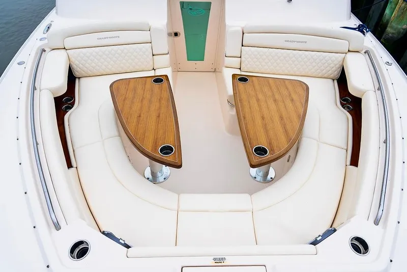 Slide: The Image of 2024 Grady-White Freedom 415 boat interior with elegant seating and dual wooden tables. - 16