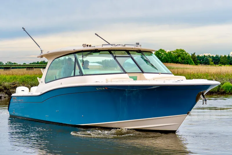 Slide: The Image of 2024 Grady-White Freedom 415 boat cruising on calm water, showcasing sleek design. - 3