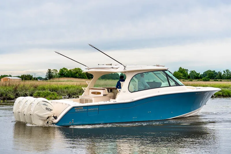 Slide: The Image of 2024 Grady-White Freedom 415 boat cruising on calm water, side view. - 4