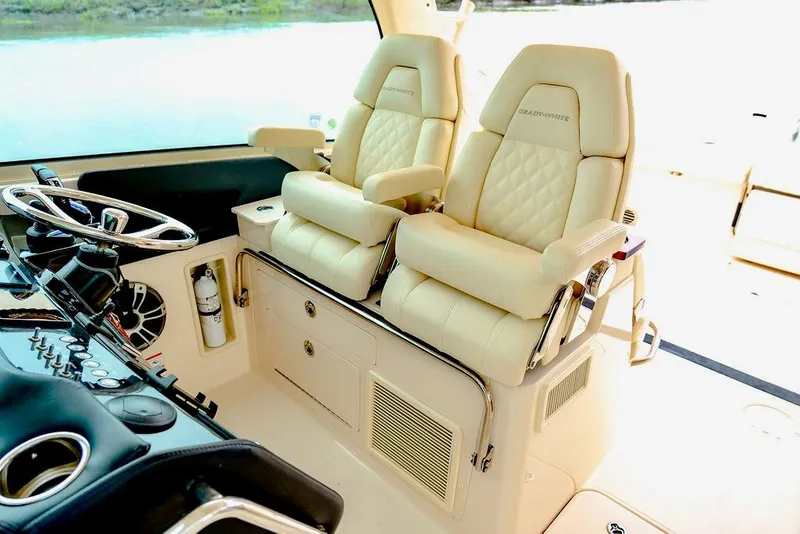 Slide: The Image of 2024 Grady-White Freedom 415 boat interior with luxurious beige seating and modern controls. - 8