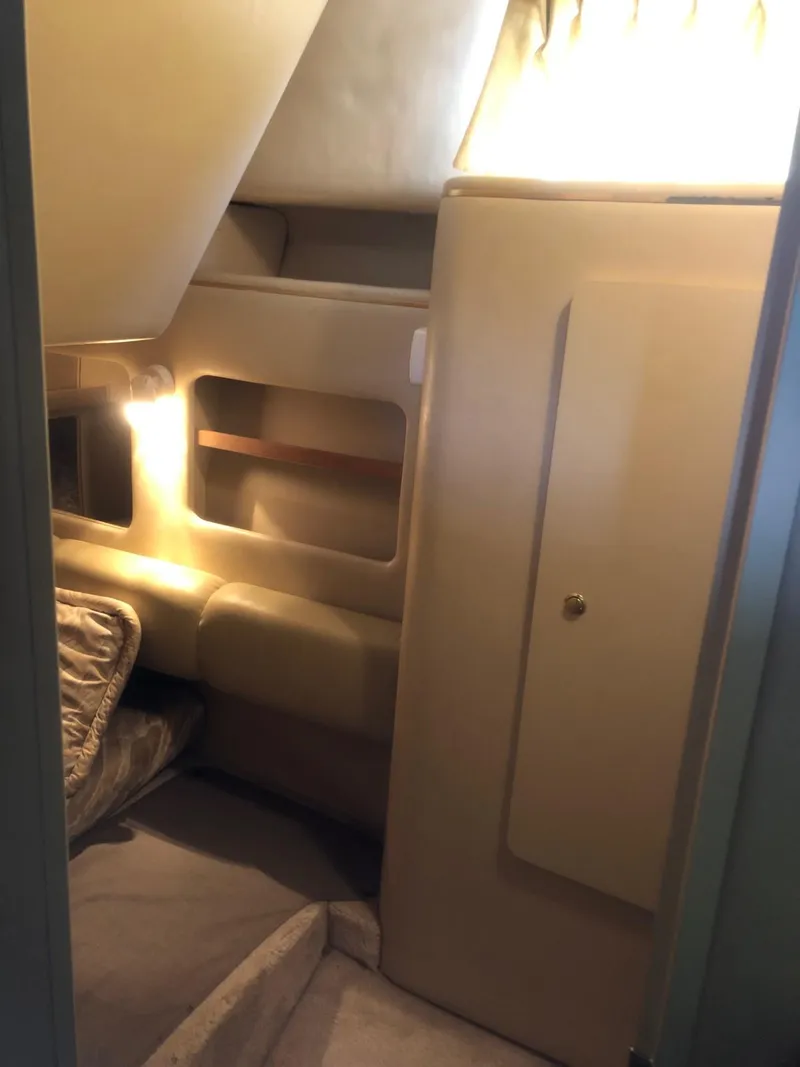 Slide: The Image of 1998 Sea Ray 290 Sundancer cabin interior with cozy seating and ambient lighting. - 10