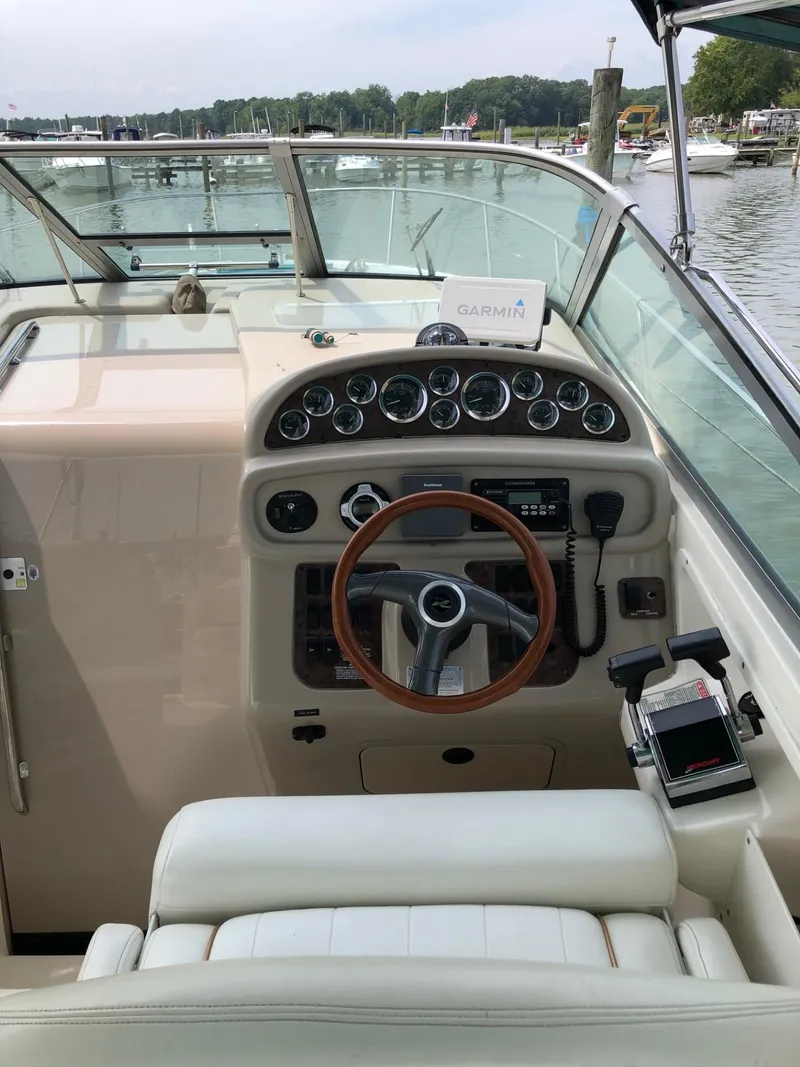 Slide: The Image of 1998 Sea Ray 290 Sundancer helm with gauges, steering wheel, and navigation equipment. - 4
